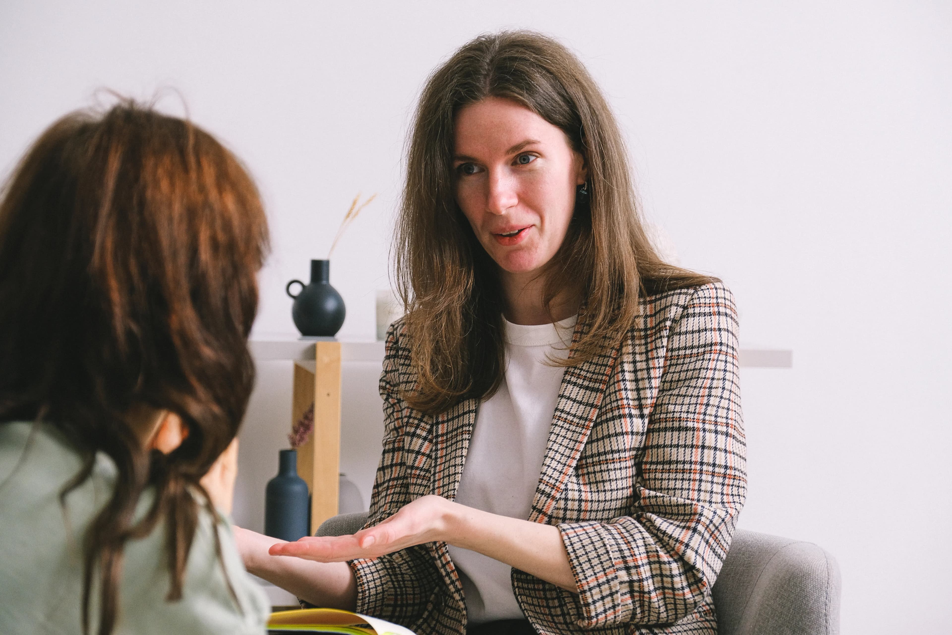 Therapist speaking with a client in a calm therapy office